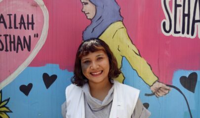 MSF Staff, Stephanie Amalia, in front of colourful mural