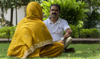 Patient treated for kala azar-HIV co-infection and tuberculosis in India, is speaking with MSF health promoter.